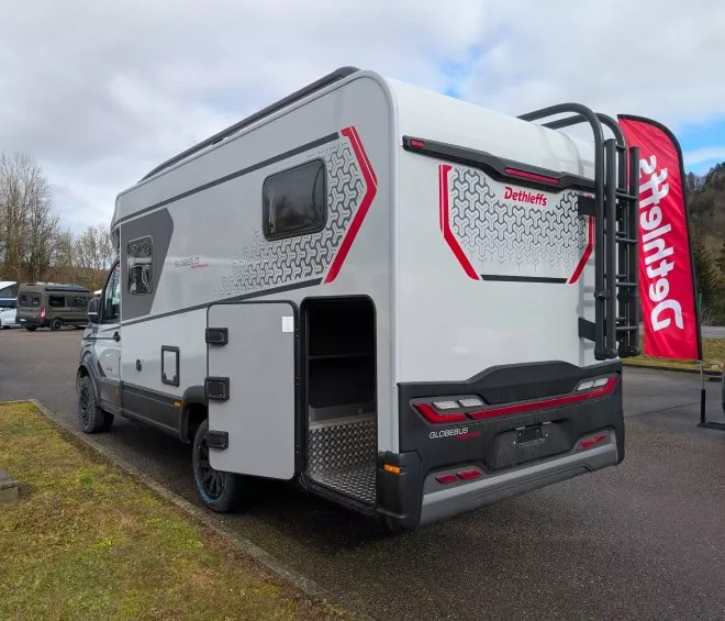 Camping-car Dethleffs Globebus sur un parking, ciel nuageux en arrière-plan.