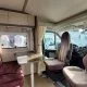 Intérieur d'un camping-car avec sièges et table, ambiance confortable.