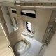 Salle de bain compacte avec douche, lavabo et toilettes dans un camping-car moderne.