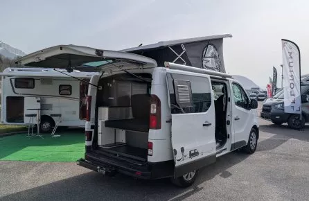 Fourgon aménagé avec toit relevable exposé sur un parking