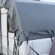 Bâche de protection grise couvrant le toit d'une caravane stationnée.