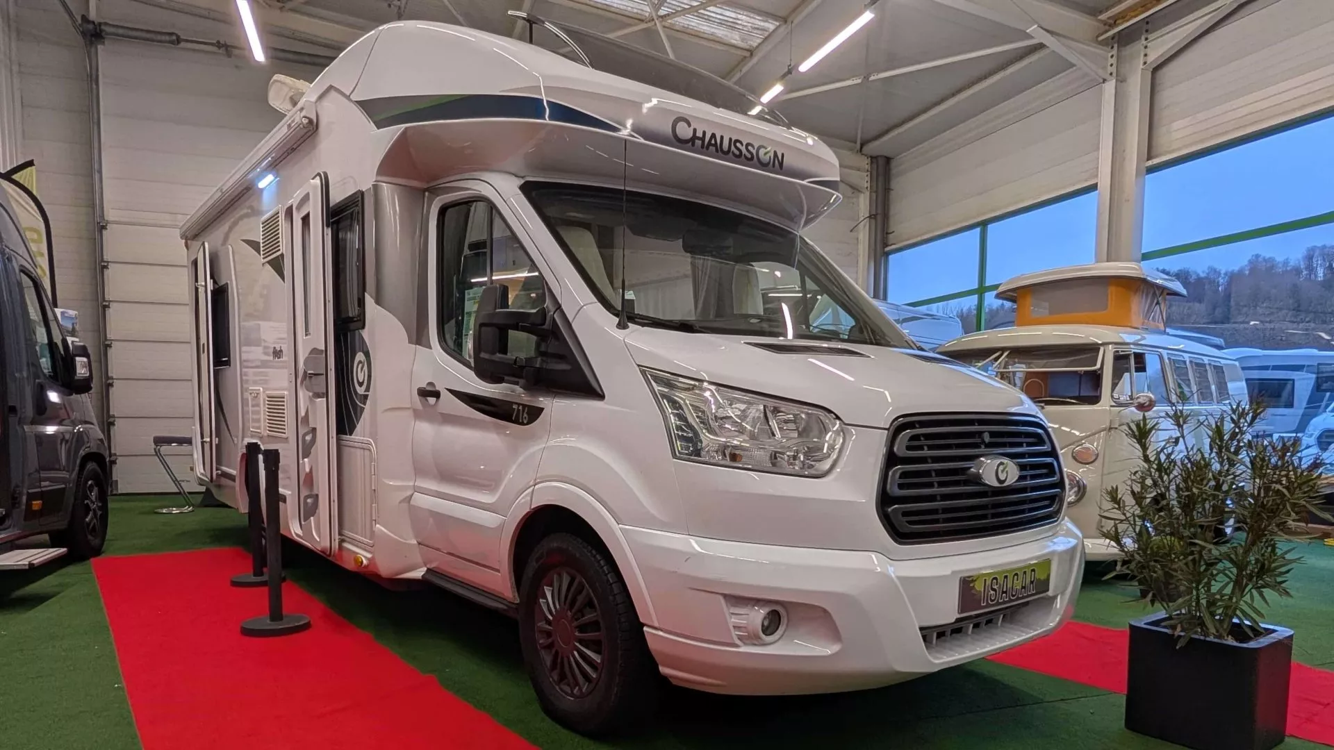 Camping-car Chausson exposé dans un showroom avec tapis rouge