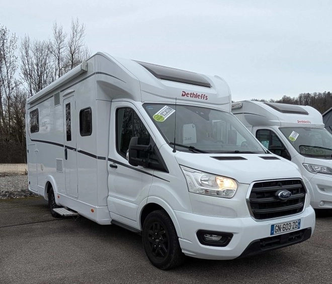 Camping-car Dethleffs blanc stationné sur un parking, modèle Just 90.