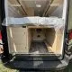 Intérieur d'un van aménagé avec lit et rangements en bois clair