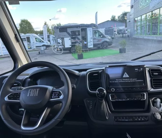 Vue intérieure d'un camping-car Fiat avec tableau de bord et écran LCD