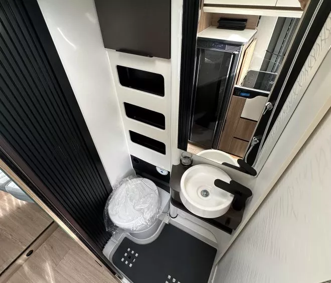 Salle de bain compacte avec toilettes et lavabo dans un camping-car moderne
