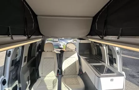 Intérieur d'un van aménagé avec sièges et kitchenette moderne