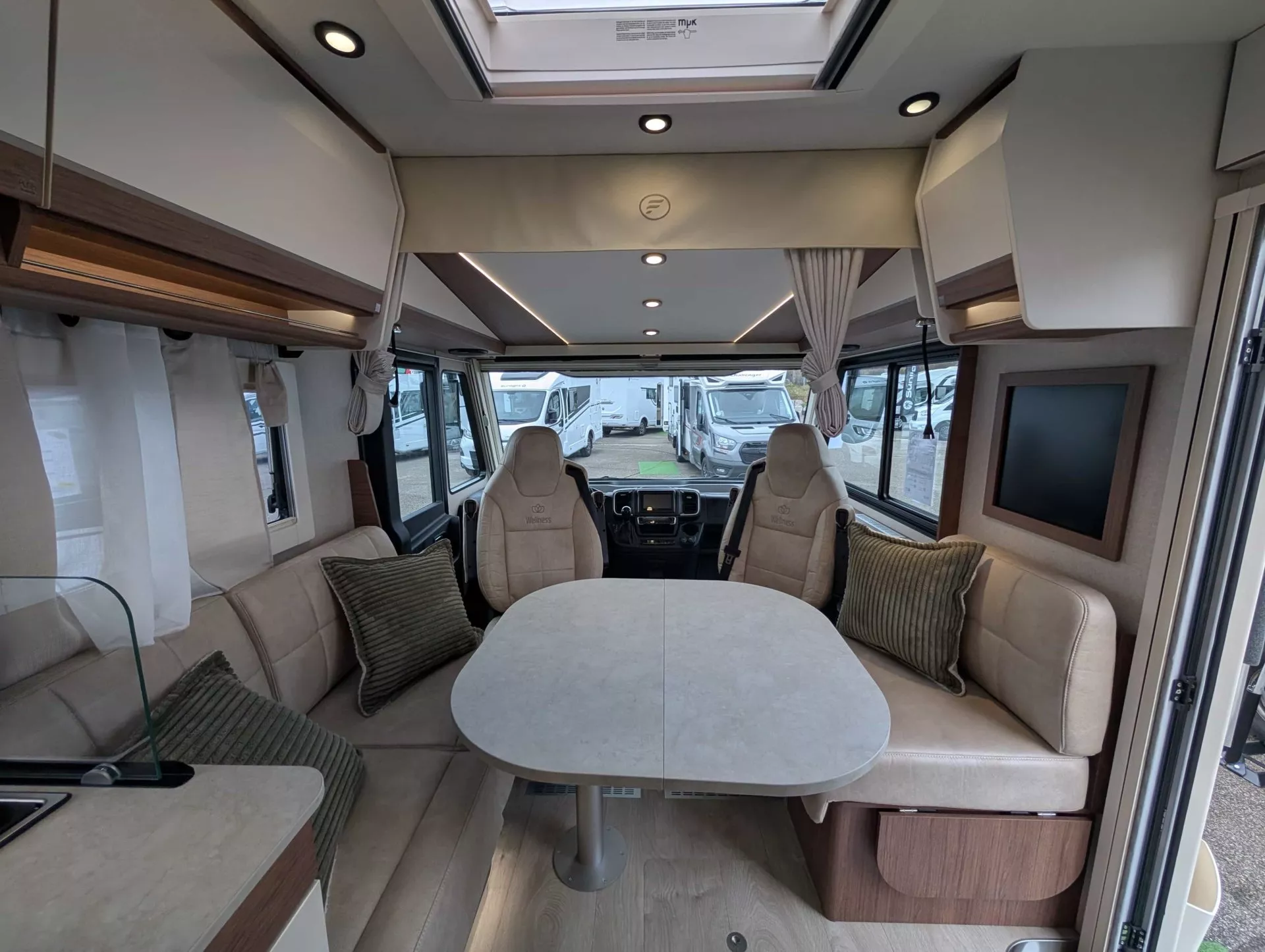 Intérieur d'un camping-car moderne avec table et sièges en cuir beige