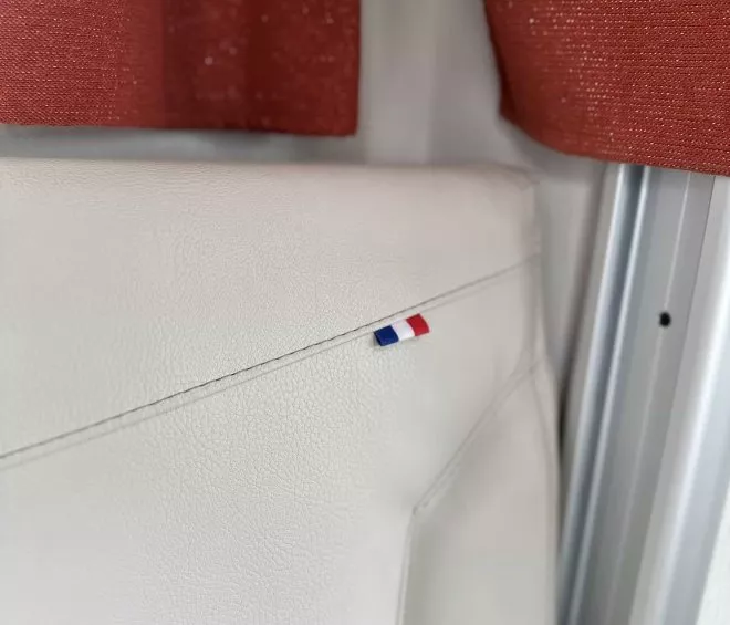 Dossier de siège en cuir blanc avec drapeau français, rideau rouge en arrière-plan