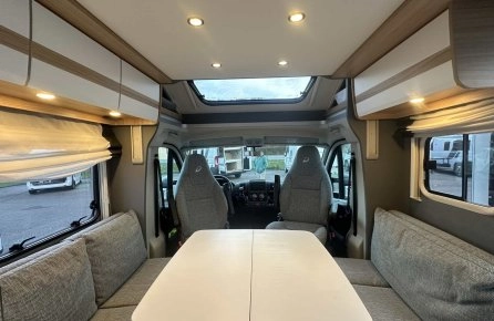 Intérieur d'un camping-car moderne avec table et sièges gris