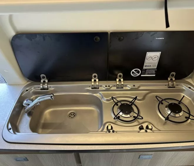 Évier et plaque de cuisson à deux feux dans une cuisine de camping-car.