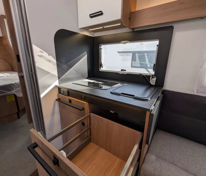 Cuisine compacte de camping-car avec tiroir ouvert et plaque de cuisson