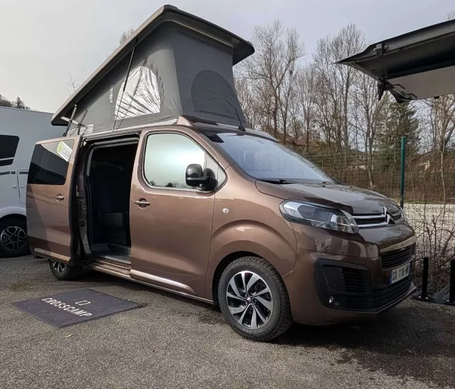 Van aménagé avec toit relevable sur un parking, modèle Crosscamp.