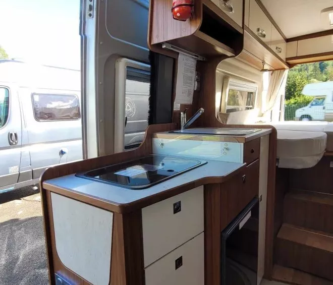 Intérieur d'un camping-car avec kitchenette et rangements en bois