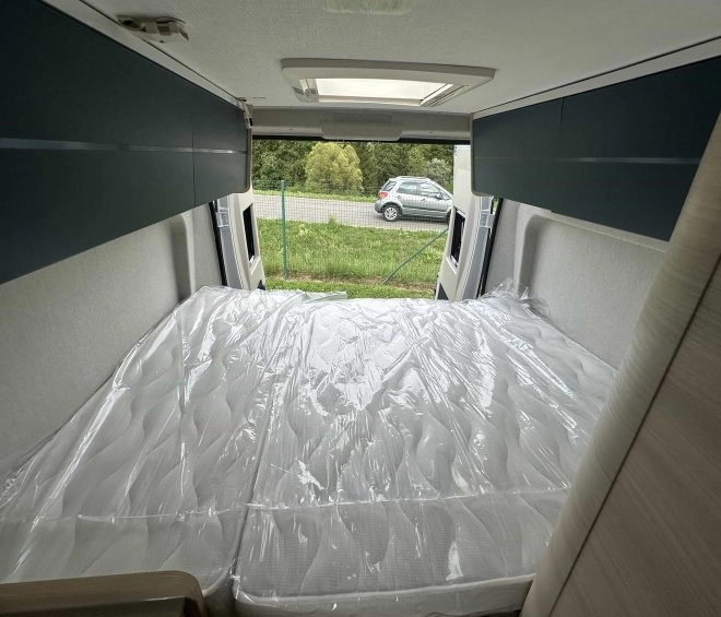 Intérieur d'un camping-car avec lit double et vue sur l'extérieur