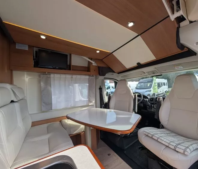 Intérieur d'un camping-car avec table et sièges en cuir beige