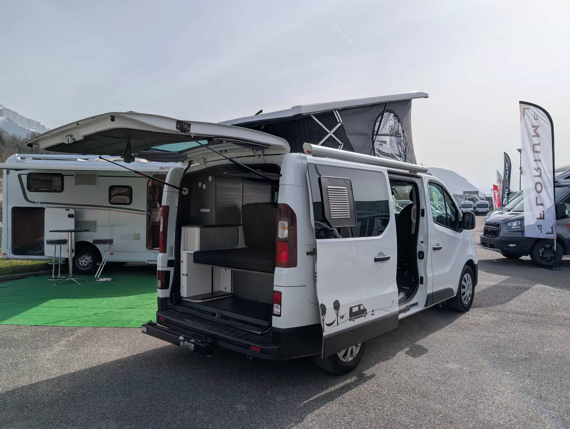 Fourgon aménagé avec toit relevable exposé sur un parking