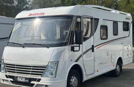 Camping-car Dethleffs blanc stationné sur un parking, modèle d'occasion.
