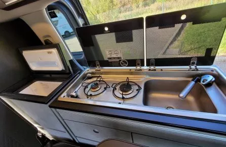 Cuisine intégrée dans un van avec réchaud à gaz et évier
