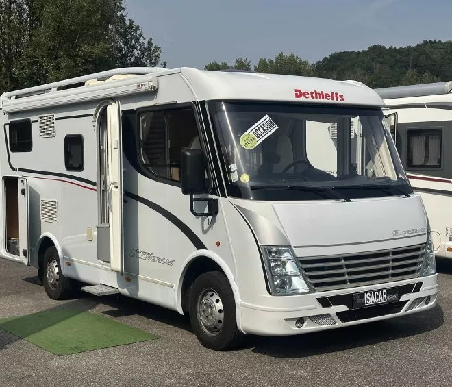 Camping-car Dethleffs blanc stationné sur un parking, porte ouverte