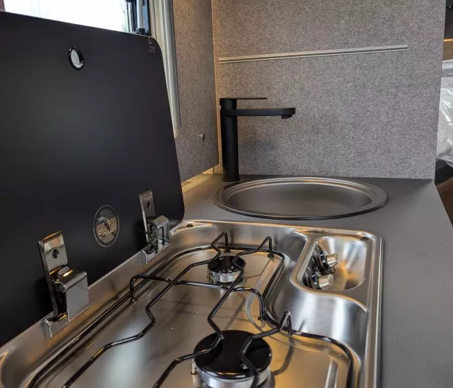 Cuisine compacte avec plaque de cuisson et évier dans un camping-car moderne