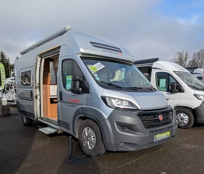 Camping-car Camperêve stationné sur un parking, porte latérale ouverte