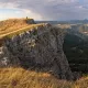 Paysage de montagne avec falaise rocheuse et vallée boisée en arrière-plan