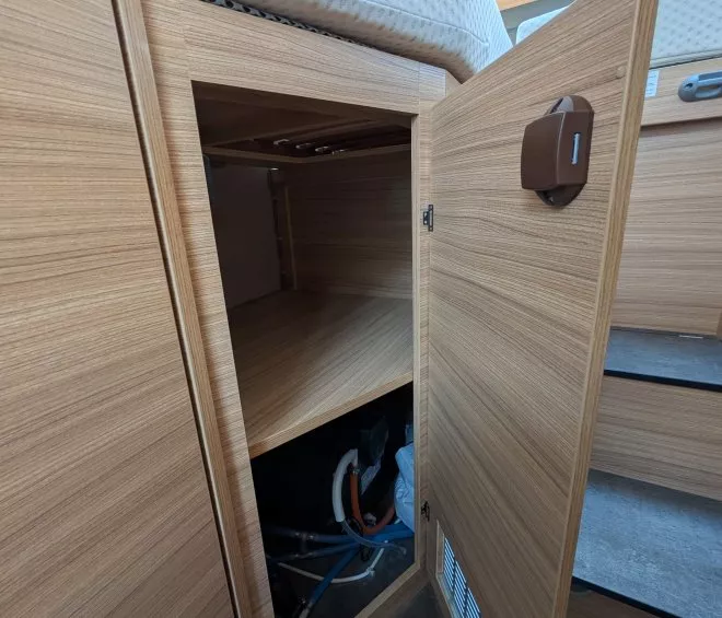 Placard en bois ouvert avec tuyaux visibles à l'intérieur