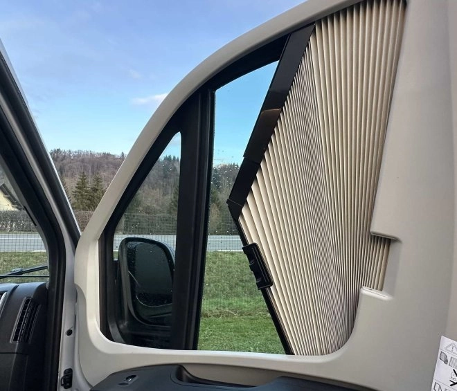 Intérieur d'un véhicule avec pare-soleil plissé sur la fenêtre latérale