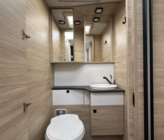 Salle de bain compacte en bois clair avec toilettes et lavabo moderne