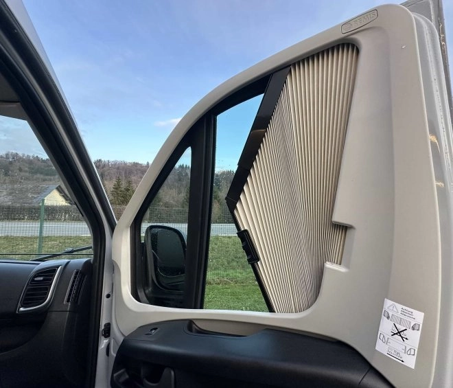 Pare-soleil plissé installé sur la fenêtre d'un véhicule utilitaire