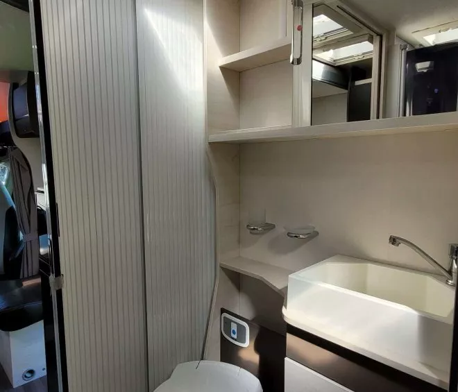 Salle de bain compacte avec toilettes et lavabo dans un camping-car moderne