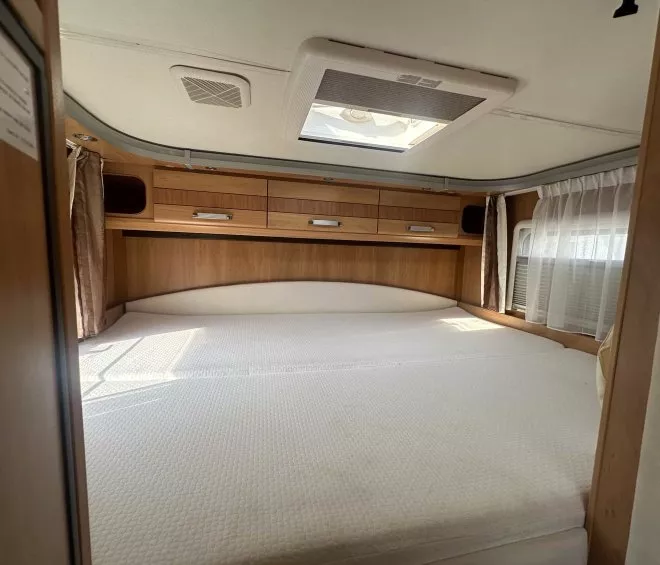Intérieur d'une caravane avec lit double et placards en bois