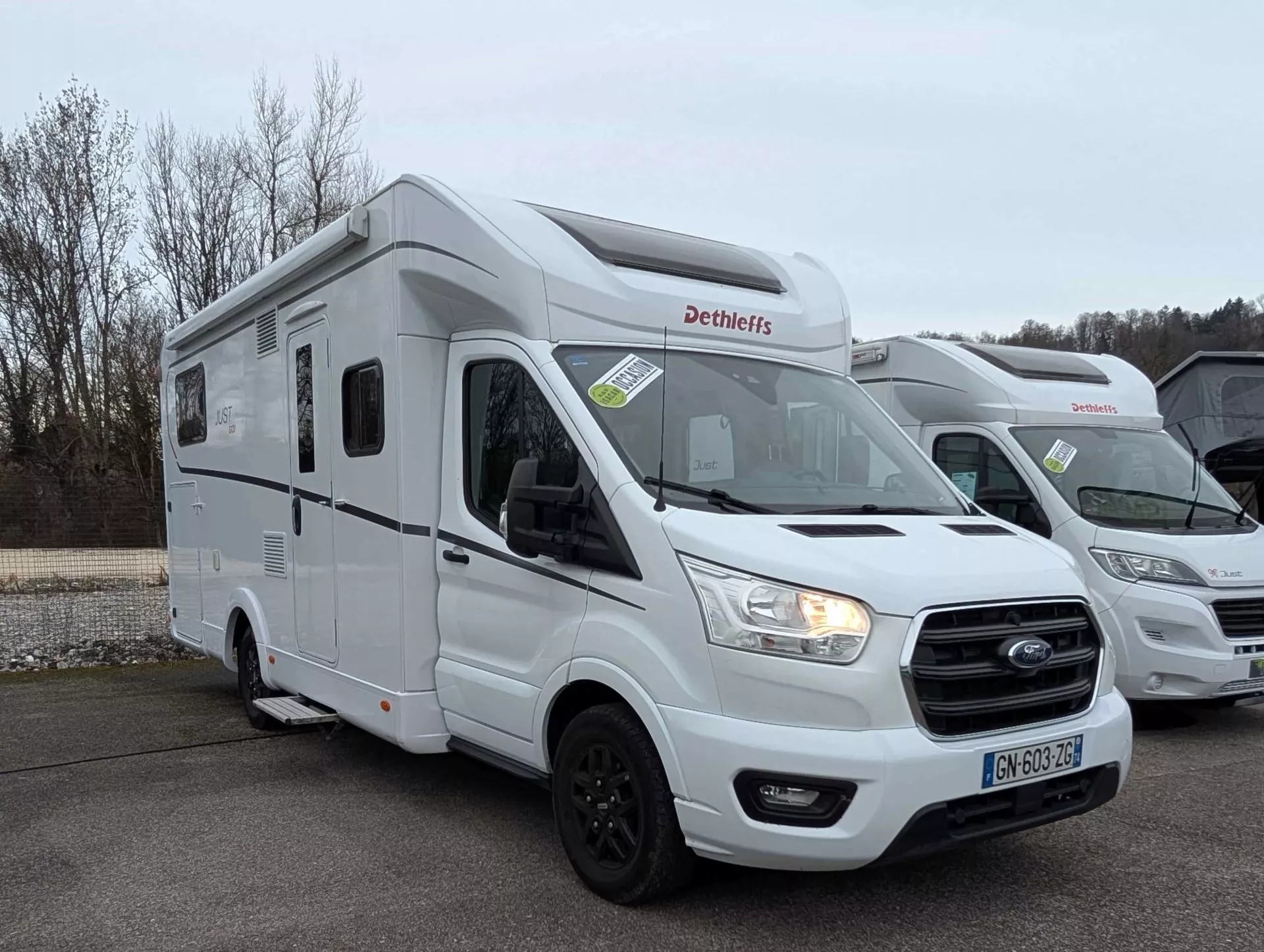 Camping-car Dethleffs blanc stationné sur un parking, modèle Just 90.