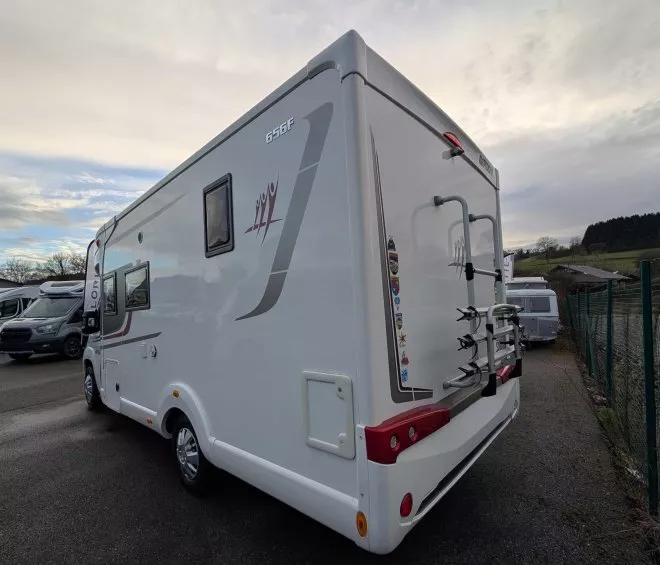 Camping-car stationné sur un parking avec ciel nuageux en arrière-plan