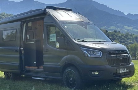 Véhicule utilitaire Ford aménagé en camping-car sur fond de montagnes