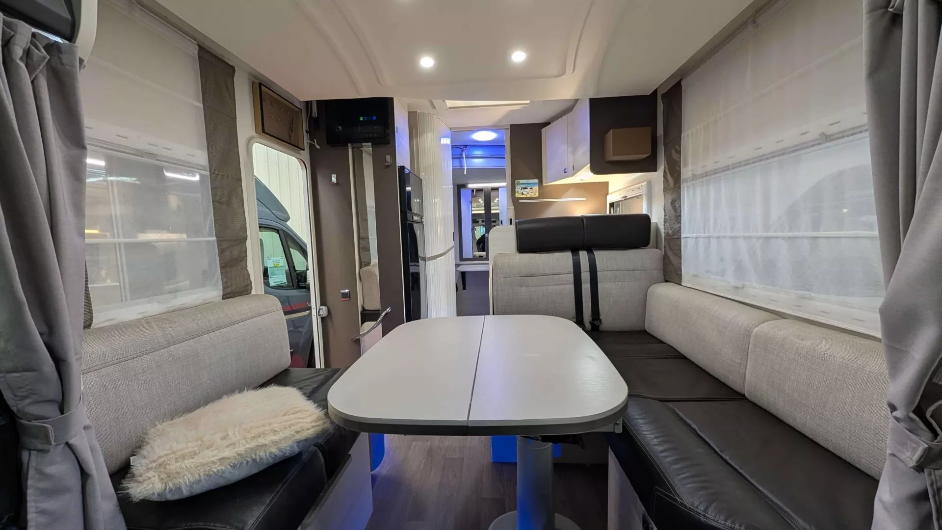 Intérieur d'un camping-car moderne avec table et banquettes grises