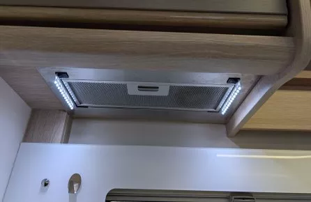 Hotte aspirante encastrée avec éclairage LED sous meuble de cuisine en bois clair