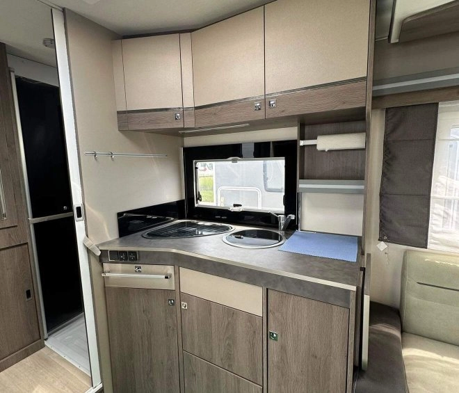 Cuisine compacte de caravane avec évier et rangements en bois clair