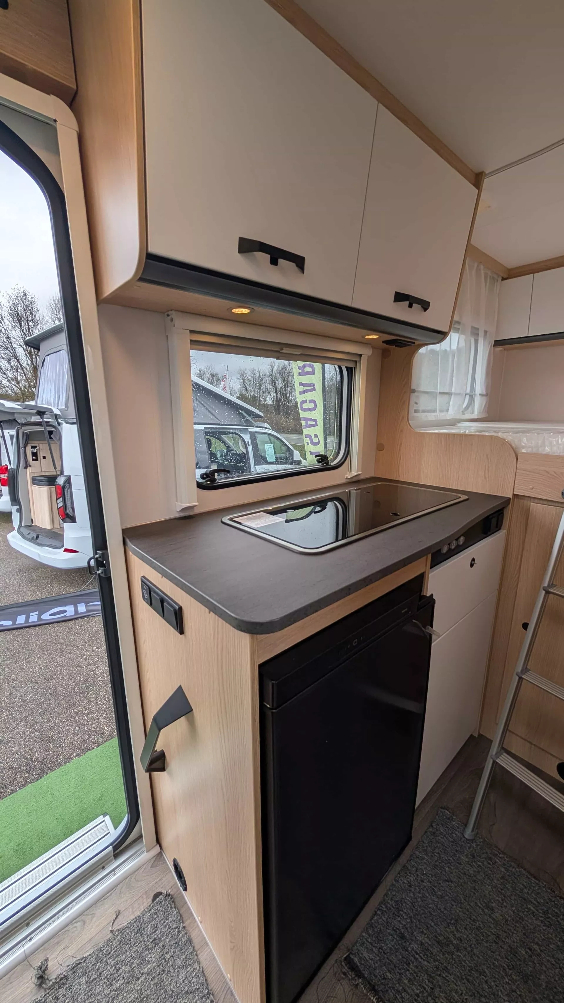 Cuisine moderne de camping-car avec plaque de cuisson et rangements