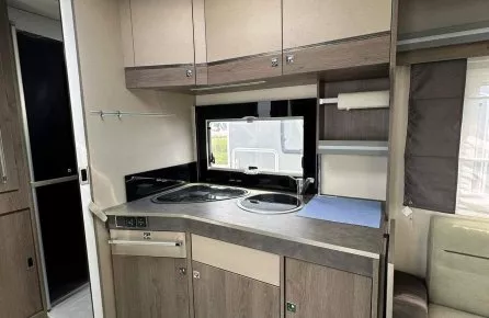 Cuisine compacte de caravane avec évier et rangements en bois clair