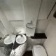 Salle de bain compacte avec lavabo, toilettes et douche dans un espace restreint.
