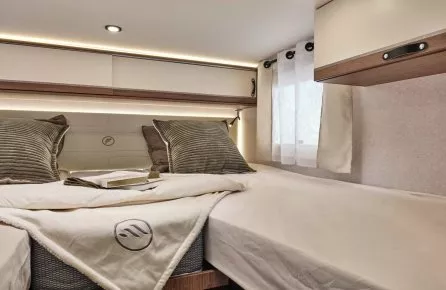 Intérieur d'une chambre de camping-car avec lit double et éclairage LED.