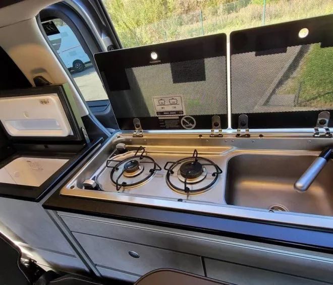 Cuisine intégrée dans un van avec réchaud à gaz et évier