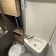 Salle de bain compacte avec lavabo, toilettes et douche dans un camping-car moderne.