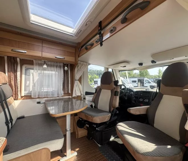 Intérieur d'un camping-car avec coin salon et table, sièges avant pivotants