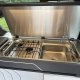 Cuisine compacte avec évier et plaque de cuisson dans un véhicule aménagé