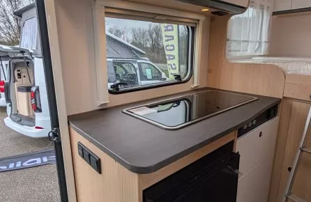 Cuisine moderne de camping-car avec plaque de cuisson et rangements