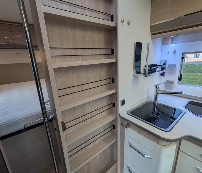 Intérieur d'une cuisine de camping-car avec évier et étagères en bois