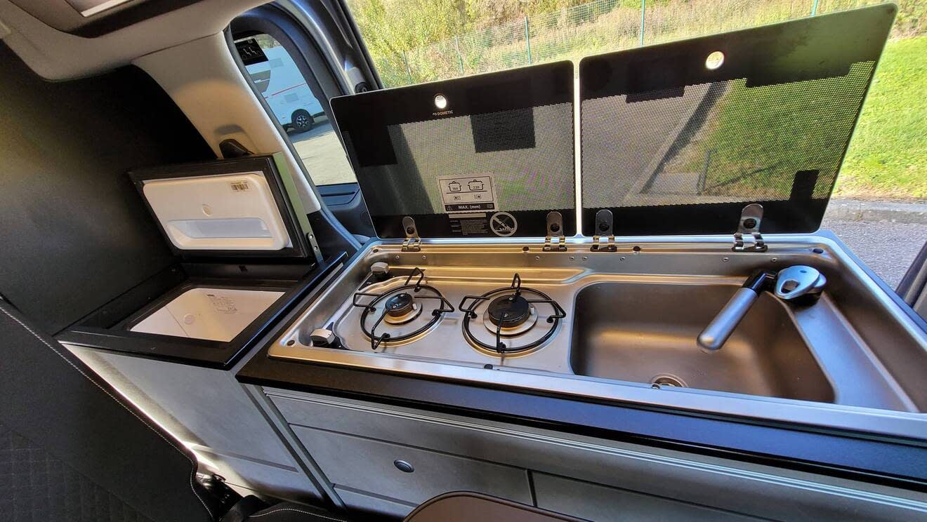 Cuisine intégrée dans un van avec réchaud à gaz et évier